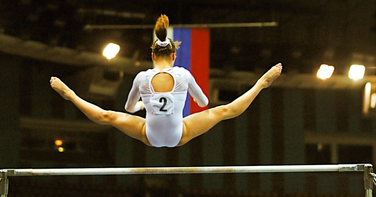 Olympic homeschoolers young woman flying over the uneven bars