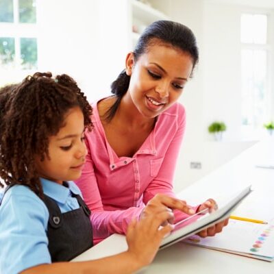 qualifications to homeschool my child black mother and child sitting at kitchen table with an ipad and workbook on table