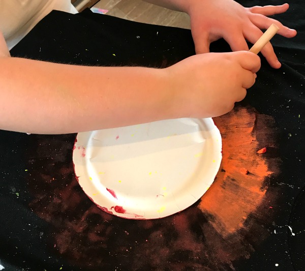 Solar Eclipse Tee Craft (How To Make a Sun Shirt Step By Step): Painting the Orange Layer Out from the Paper Plate on Top of the Red Layer on a tshirt for a DIY solar eclipse tshirt