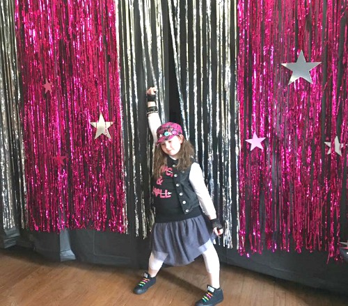 Sleepover Ideas Dance and Doze little girl in dance pose in front of shiny curtains
