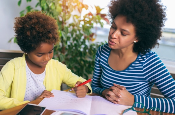 Behind In Homeschool African American mom and child working on home school at a table