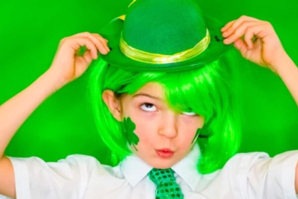 Saint Patricks Day Lessons and Fun St Fun St. Patrick's Day Activities For Kids - child with green wig and green St Patrick Day hat with green shamrock painted on face on green background