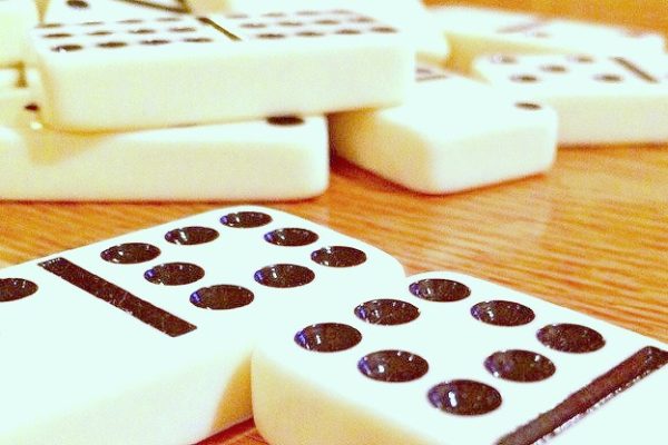 How To Play Dominoes white dominoes with black dots on a top of a table