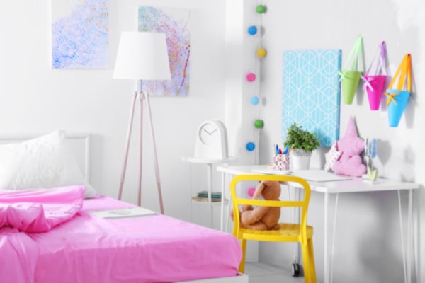 Homeschooling In a Bedroom Idea Homeschool Desk Setup small desk by bed with fun cones hanging on wall for homeschooling supplies