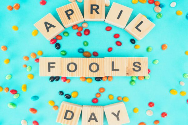 April Fools Day Tricks To Play On Kids Or Parents [April Fools Activities] the words April Fools Day spelled out with Scrabble tiles and on a bright teal background with different colored round sprinkles around it